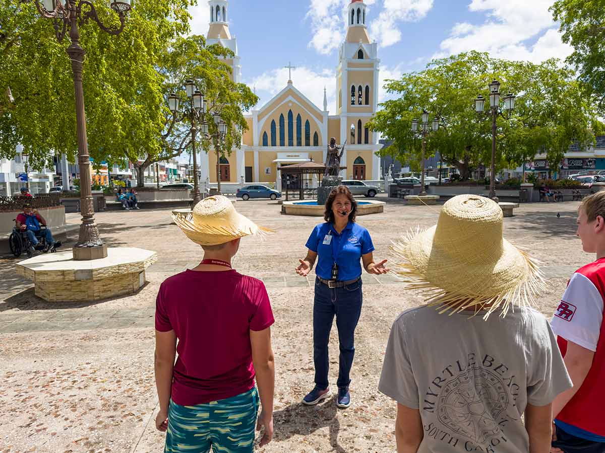 Travelers exploring a historical town with a tour guide.